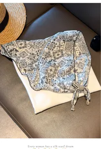 Detailed view of retro paisley print triangular head scarf featuring elegant beaded tassels.