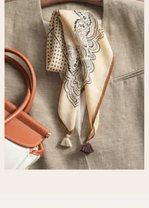 Detailed shot of vintage paisley polka dot square scarf with delicate tassels and fine fabric texture.