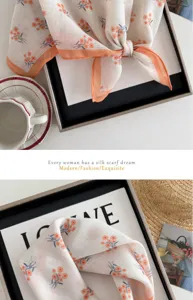 Detailed shot of a cute floral cotton-linen square scarf with orange borders and daisies.