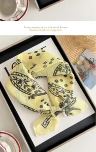 Détail élégant d'un carré en coton imprimé jaune, idéal pour un look chic et tendance.