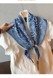 Detail view of blue and white paisley triangle scarf, linen blend fabric, fashion neck accessory.