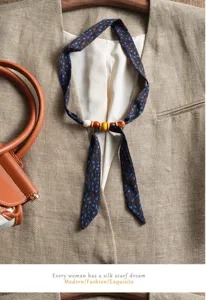 Closeup detail of retro long silk ribbon scarf with wooden beads and blue abstract pattern.