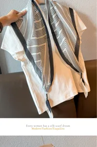 Detail shot of a black and white geometric chain print linen scarf styled with a white tee.