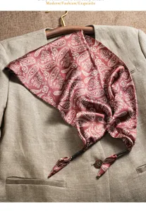 Detailed view of red paisley silk scarf draped on suit, elegant pattern and smooth texture.