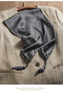 Detailed view of black and white striped silk scarf, elegant triangular shawl accessory.