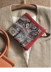 Detail view of a vintage paisley print pocket square with red border and delicate fringe tassels.