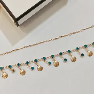 Gold layered choker necklace featuring turquoise rhinestones and cute seashell charms detail.