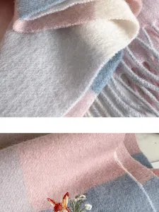 Close-up detail of soft plaid wool cashmere scarf featuring delicate floral embroidery and fringe.