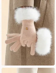 Close-up of knit winter gloves with fluffy white faux fur cuffs and a chic metallic button detail.