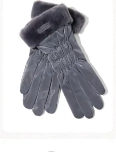 Primer plano de guantes de esquí de invierno grises para mujer con puños de peluche para frío.