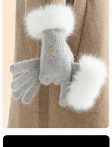 Detail view of winter grey knitted gloves featuring soft white faux fur cuffs and small metal button.