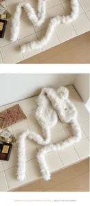 Vue détaillée de mignons cache-oreilles en peluche blanche avec de longs liens, accessoire d'hiver.