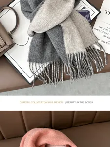 Detail view of two-tone grey and beige wool scarf with fringes, warm winter accessory.
