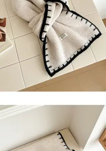 Cozy knitted scarf with contrast black edge, stylish winter warm woolen shawl for daily wear.