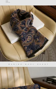 Detailed view of the coffee blue merino wool paisley scarf draped on a white box and chair.