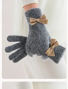 Détail de gants en tricot pelucheux gris avec joli nœud et accent métallique pour l'hiver.