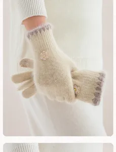 Gros plan de gants d'hiver duveteux avec charm floral mignon, tissu tricoté chaud et doux