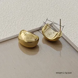 Nahaufnahme der stilvollen minimalistischen goldenen C-Ohrringe mit exquisiter Textur.