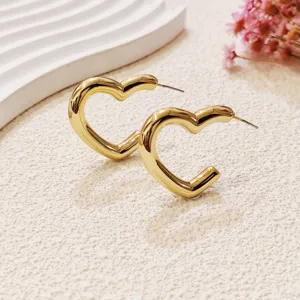 Vue détaillée de boucles d'oreilles cœur en or, design métallique minimaliste pour style.