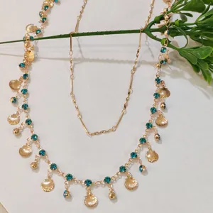 Detailed view of the double layer gold choker necklace with blue rhinestones and shell charms.