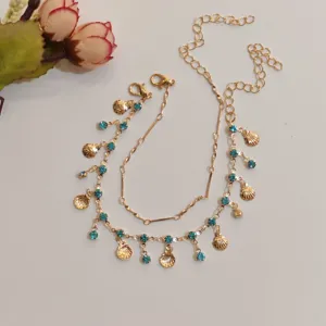 Double-layer gold necklace detail featuring blue rhinestones and shell charms for daily chic wear.