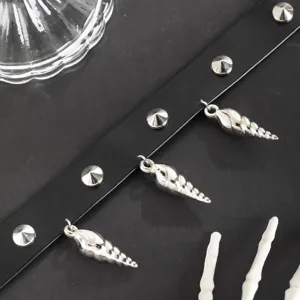 Close-up of gothic punk black leather choker necklace with metal spikes and silver conch charms.