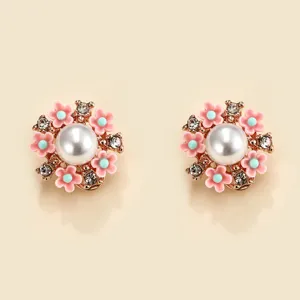 Exquisite detail of pearl and pink flower stud earrings featuring sparkling rhinestones.