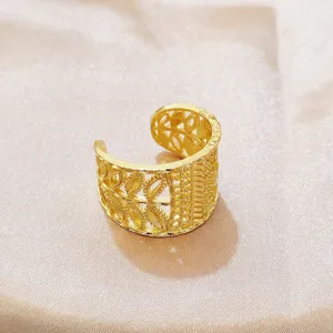 Detaillierte Nahaufnahme eines goldenen Retro-Öffnungsrings mit filigranen Blattmustern.
