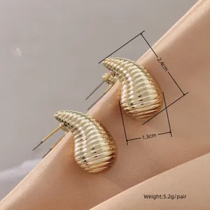 Closeup of elegant gold plated textured teardrop stud earrings, 2.4cm size detail view.