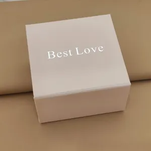 Detailopname van een elegante roze vierkante geschenkdoos met mooie zilveren belettering.