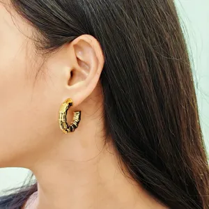 Detailed shot of retro gold bamboo texture hoop earrings, fashion geometric ear jewelry.