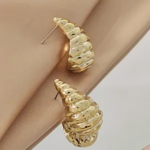 Close-up detail of gold conch shaped stud earrings, showcasing textured metallic luster.