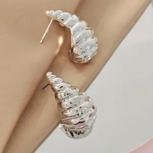 Detail shot of silver textured conch earrings, showing exquisite metallic luster and shape.