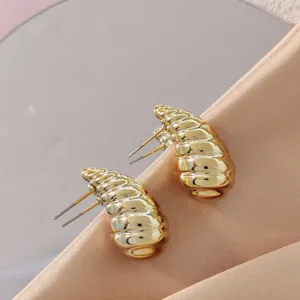 Chunky gold plated statement stud earrings featuring unique rippled texture and glossy finish.