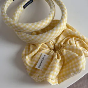 Detail shot of yellow gingham headband and scrunchie set, showing clear fabric texture.