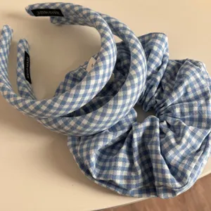 Blue and white gingham hair accessories detail view, showing cute plaid headbands and scrunchie.