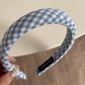 Blue gingham headband detail showing soft fabric wrap, puffy sponge design, and neat inner label.