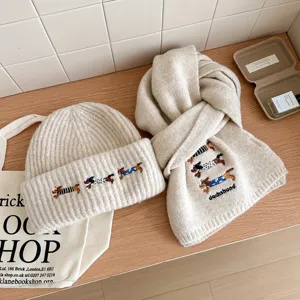 Conjunto de gorro y bufanda de punto cálido de invierno con bordado de teckel lindo crema