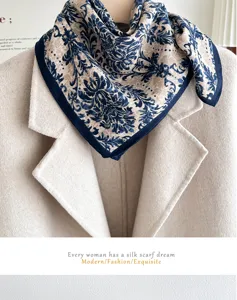 Detailed view of beige and blue silk square scarf with elegant vintage baroque floral pattern.