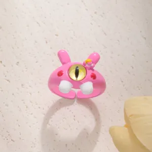 Primo piano di simpatico anello mostro dei cartoni animati, anello rosa con grande occhio.
