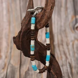Detailed close-up view of bohemian turquoise and coconut shell beaded bracelet with metal clasp.