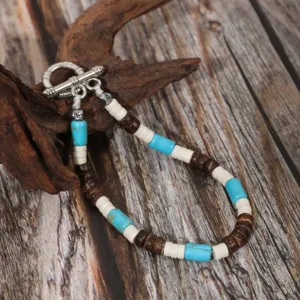 Close-up of handmade ethnic turquoise coconut shell beaded bracelet with silver toggle clasp.