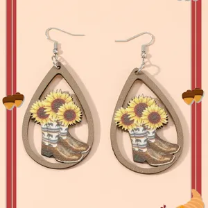 Vue détaillée de boucles d'oreilles en bois en forme de goutte avec tournesol et bottes.