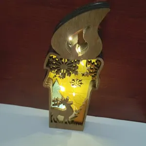Détail de bougie de Noël en bois, design flocon renne ajouré avec guirlande LED.
