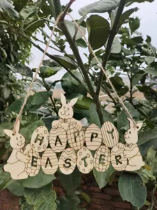 Wooden Easter hanging decoration featuring cute bunnies and carved eggs for party.