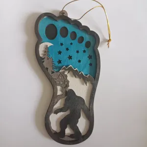 Wooden Bigfoot hanging ornament with layered woodland scene, rustic holiday tree decor detail.