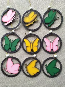 Close-up of colorful wooden butterfly hanging pendants arranged in a neat grid for home decor.