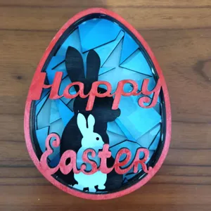 Ornement en bois en forme d'œuf de Pâques multicouche avec des silhouettes de lapin pour la déco.