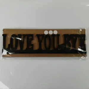 Detail panneau en bois, lettres noires decoupees decoration murale interieure fete.