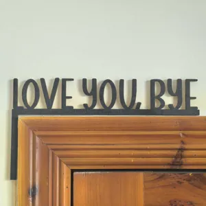 Gros plan sur le panneau d'angle de cadre de porte en bois noir avec texte LOVE YOU BYE.